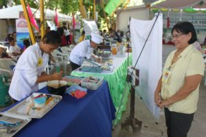 (4) Ms. Carmen Sabandal, one of the judges of the Sweet Potato and Packaging Technology Contest, carefully checked out the participants